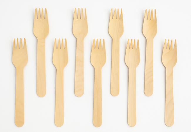 Set of biodegradable bamboo forks arranged on a white background