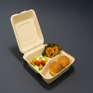 Bamboo fiber clamshell food container with three compartments holding salad, onion rings, and mini burgers