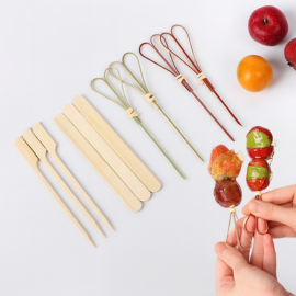 Various bamboo skewers including loop knot and flat paddle designs used to hold candied fruits and snacks.