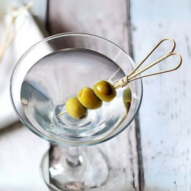 Bamboo knot skewer with loop top used to serve olives in a cocktail glass.