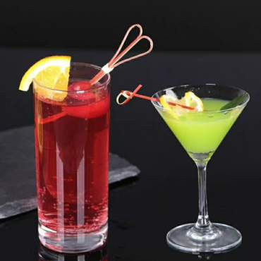 Eco-friendly bamboo cocktail skewers used to garnish drinks with lemon slices and cherries on a black background.