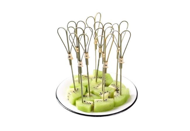 Kiwi fruit cubes served with natural bamboo knot skewers on a white plate.