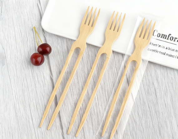 Set of bamboo chop-forks with eco packaging on light background