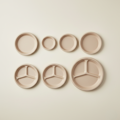 Top view of bamboo fiber disposable plates in assorted sizes, including round and 3-compartment plates for bulk and wholesale supply.